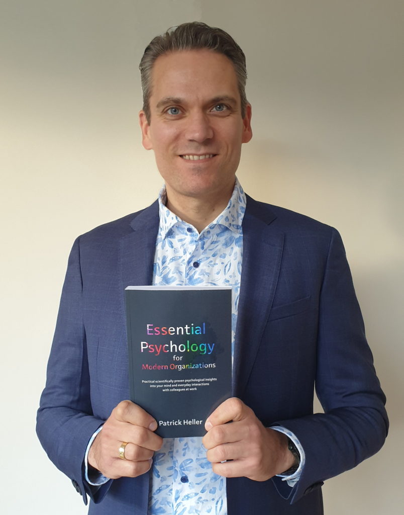 Patrick Heller holding first paperback author copy of Essential Psychology for Modern Organizations